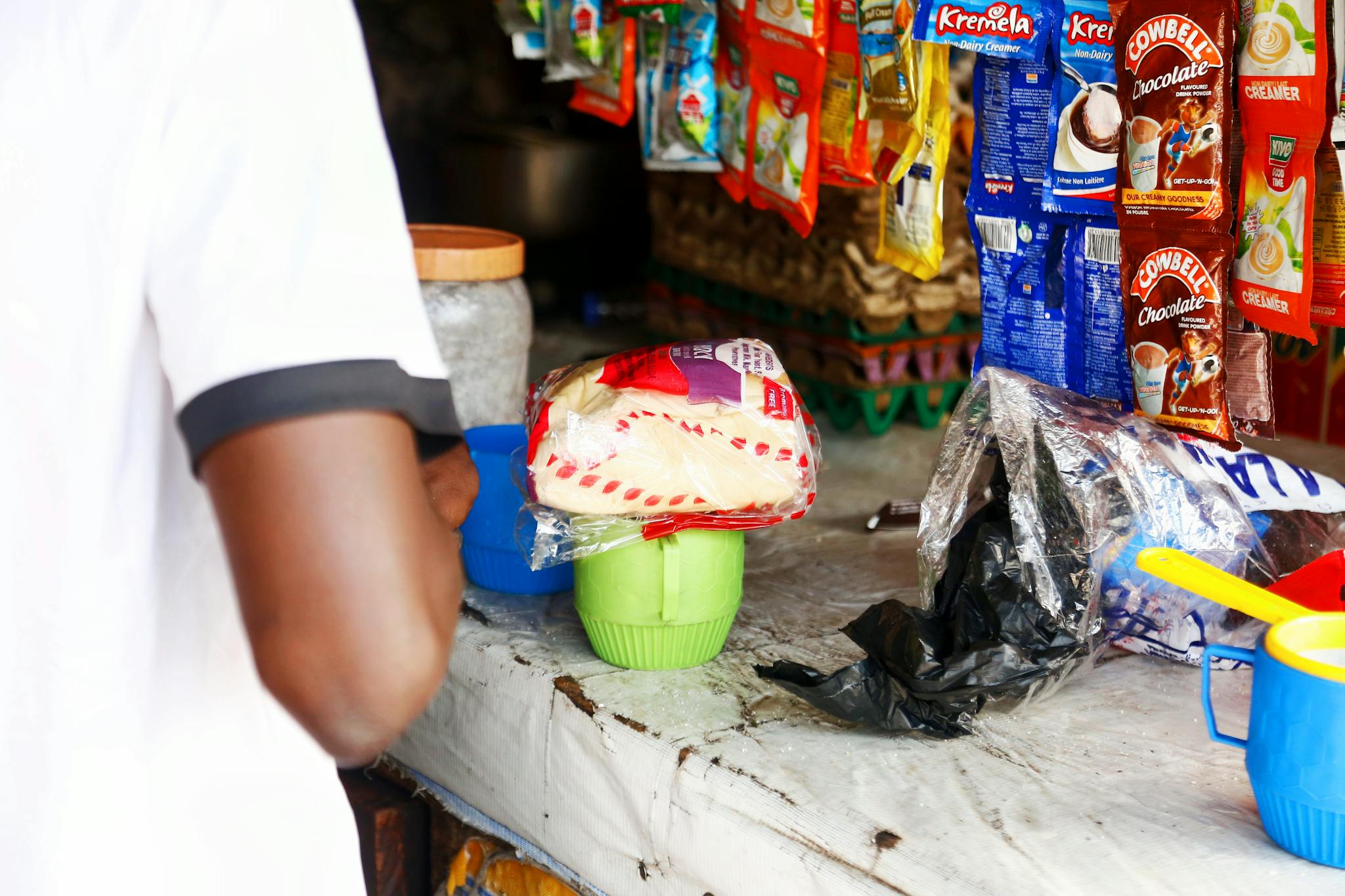 A local market stall in Abuja displaying various packaged goods on a counter.