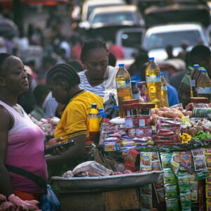 Bustling street market scene in Monrovia, Liberia, featuring diverse people and colorful stalls.