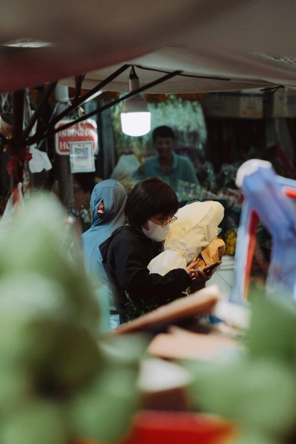 Shoppers exploring a bustling street market filled with diverse goods and vibrant atmosphere.